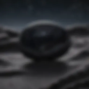 Black obsidian worry stone positioned on a reflective surface under a blanket of starlit sky