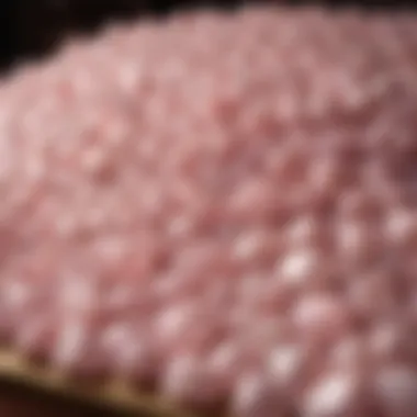 An organized display of bulk rose quartz stones in a vendor's market setting.